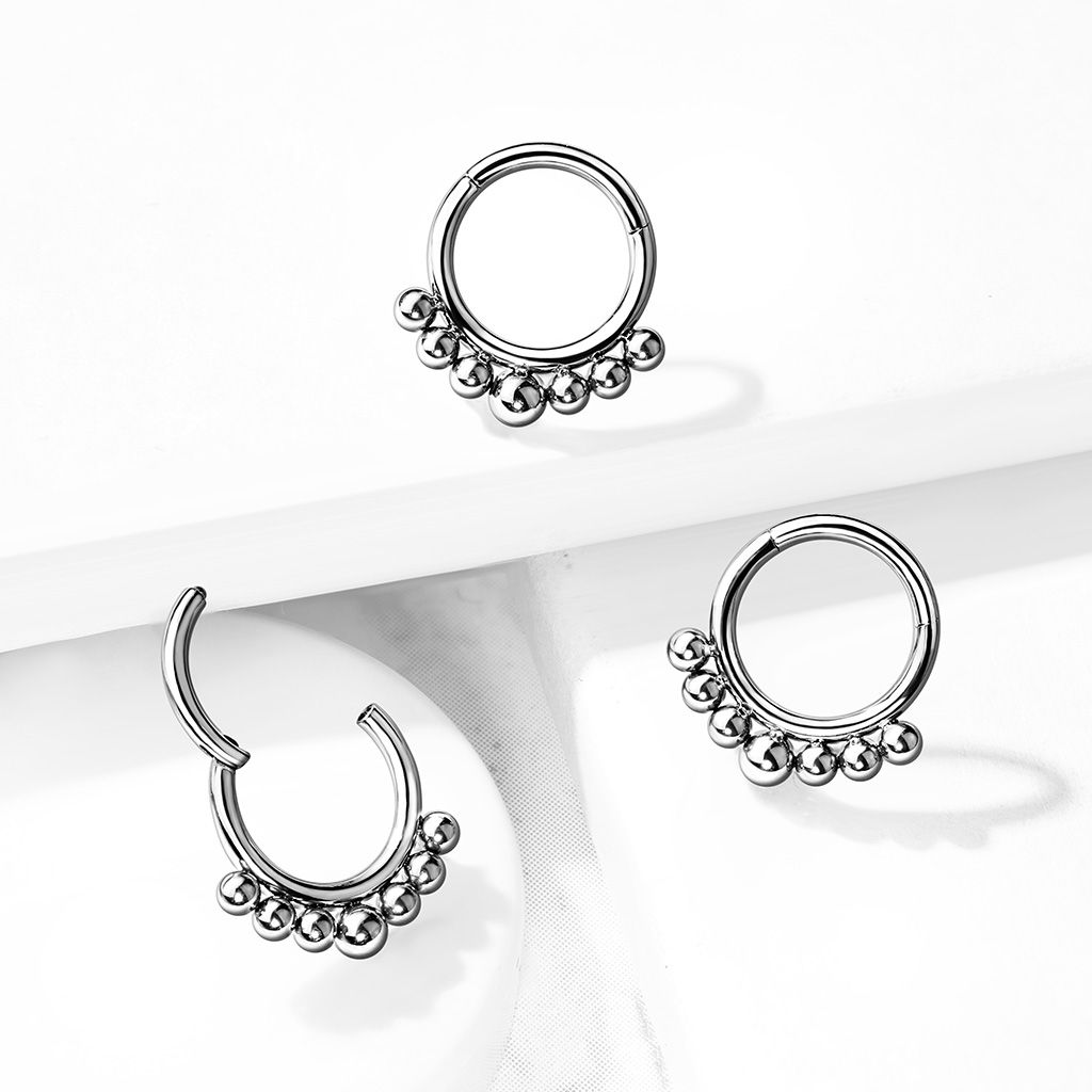 Ring made of titanium with a hinge and small beads