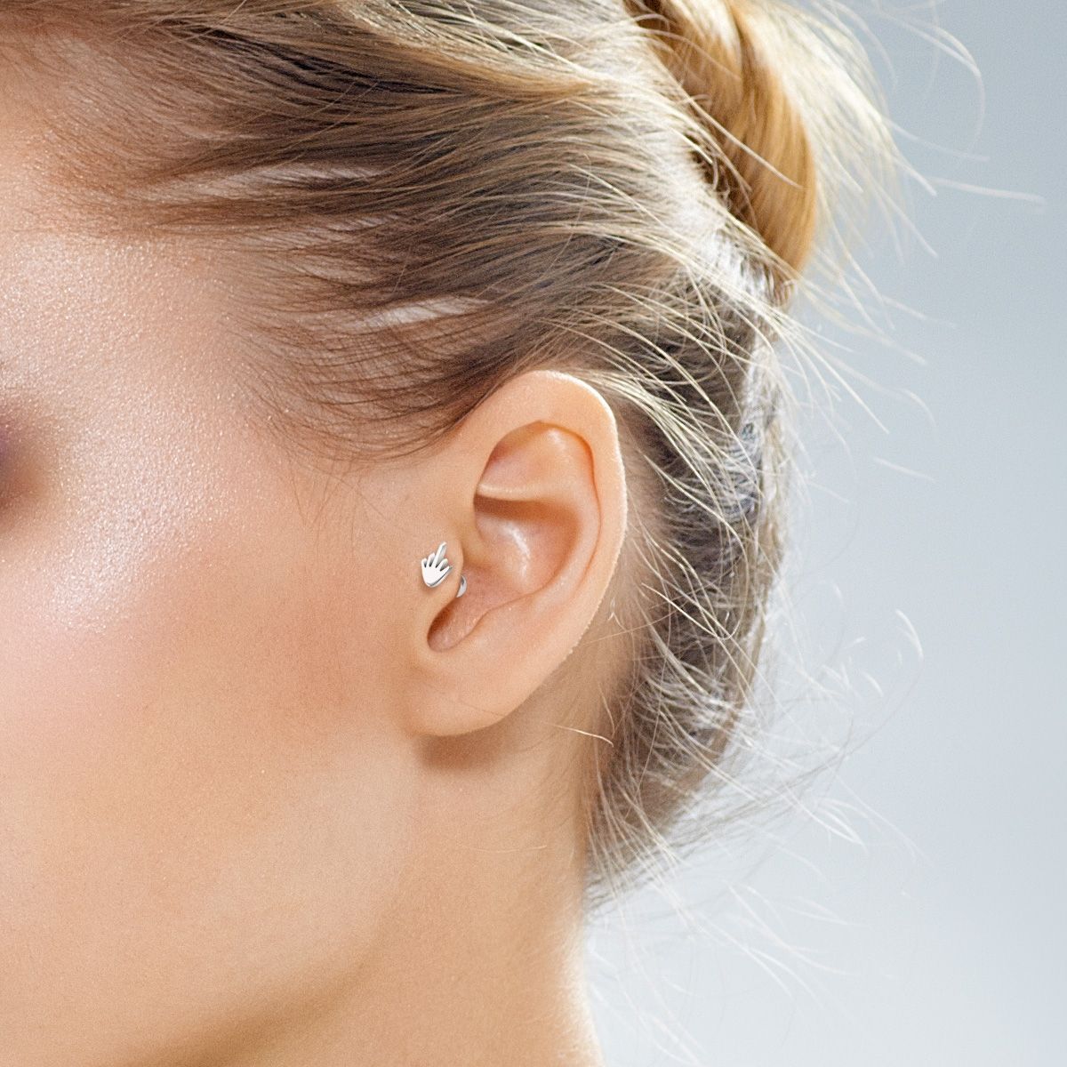 Ear piercing with fuck you finger