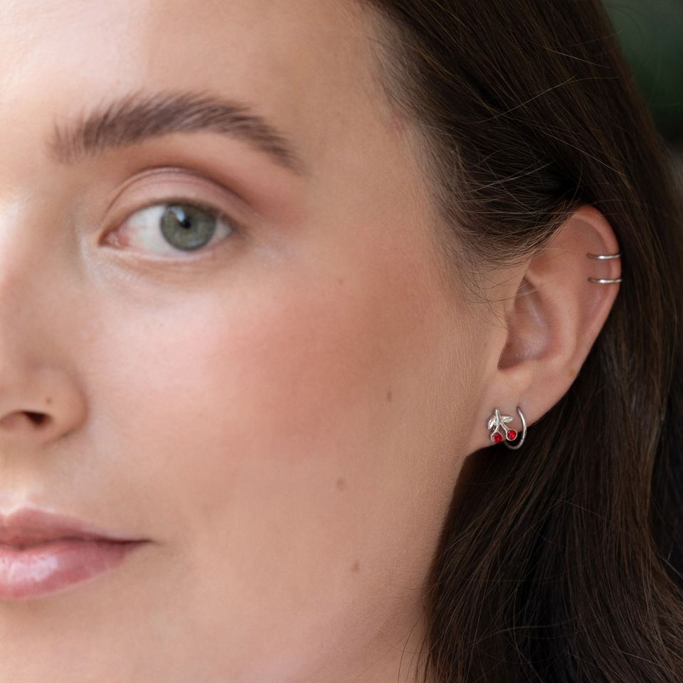 Ear piercing with red cherries