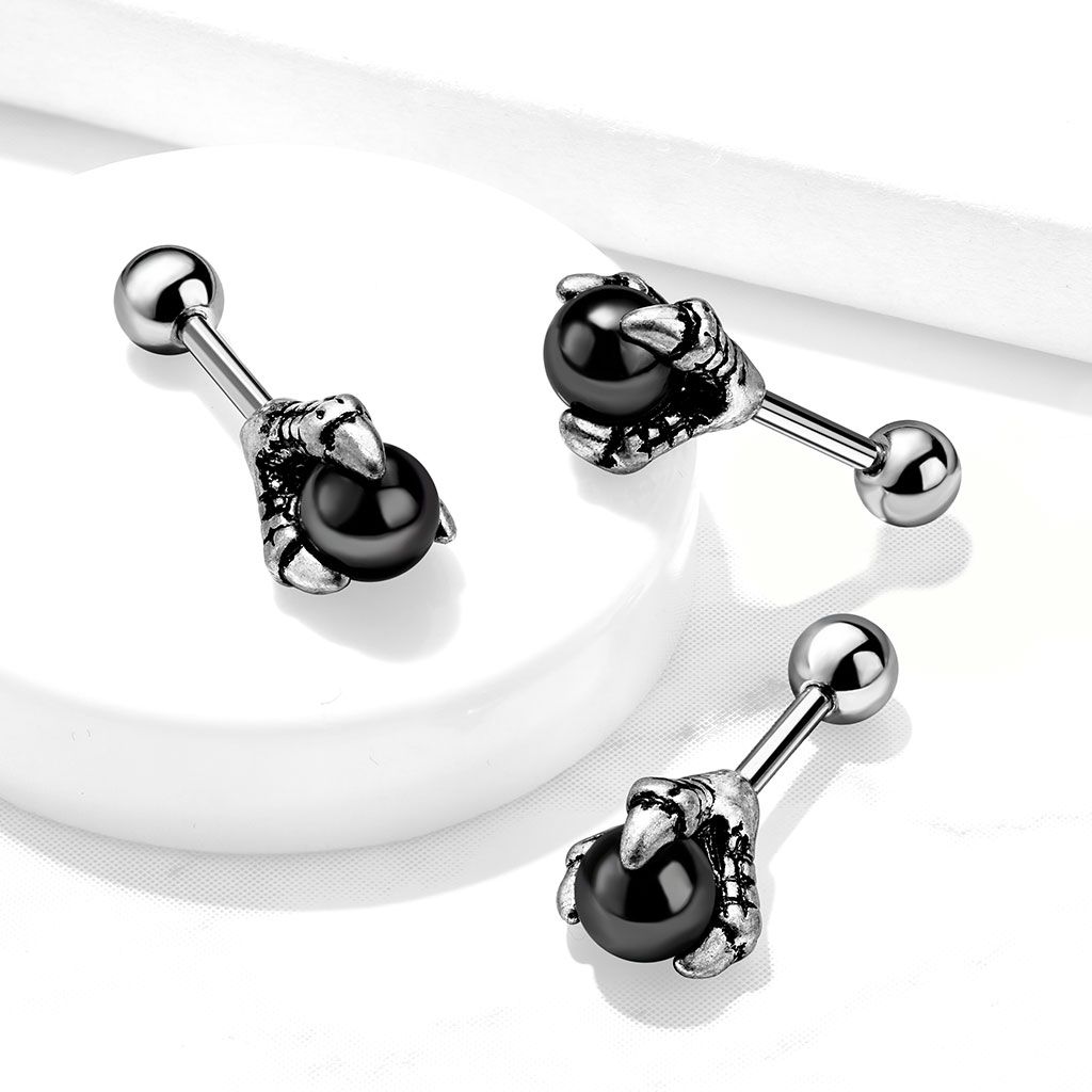 Ear piercing with black ball in dragon claw