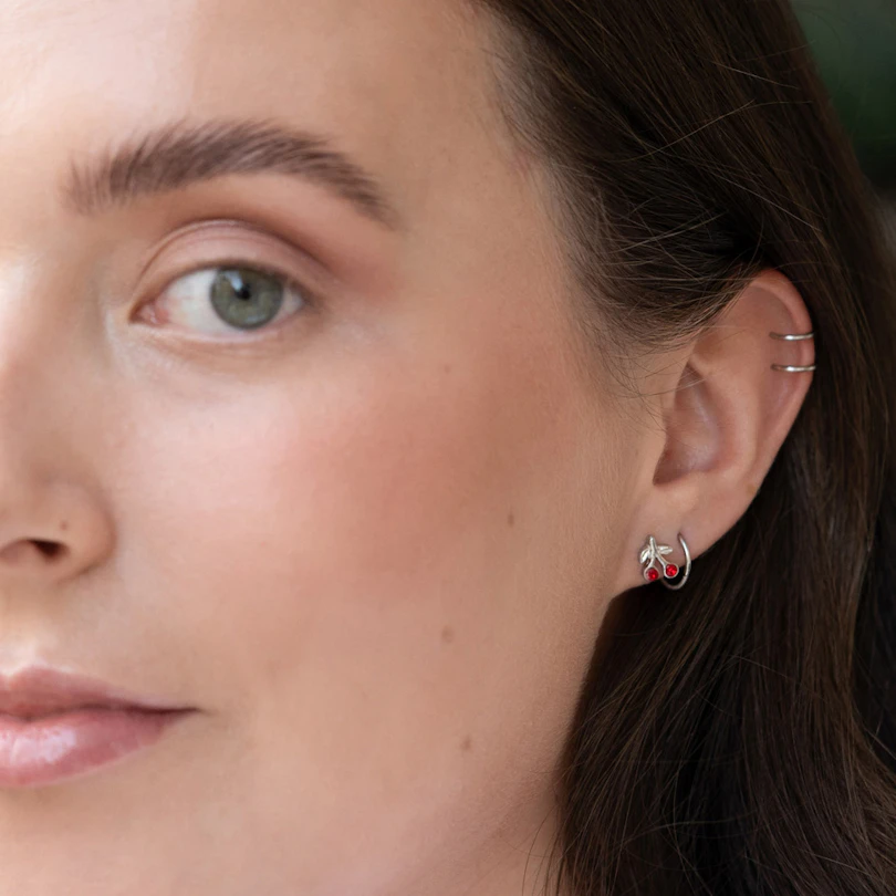 Ear piercing with red cherries