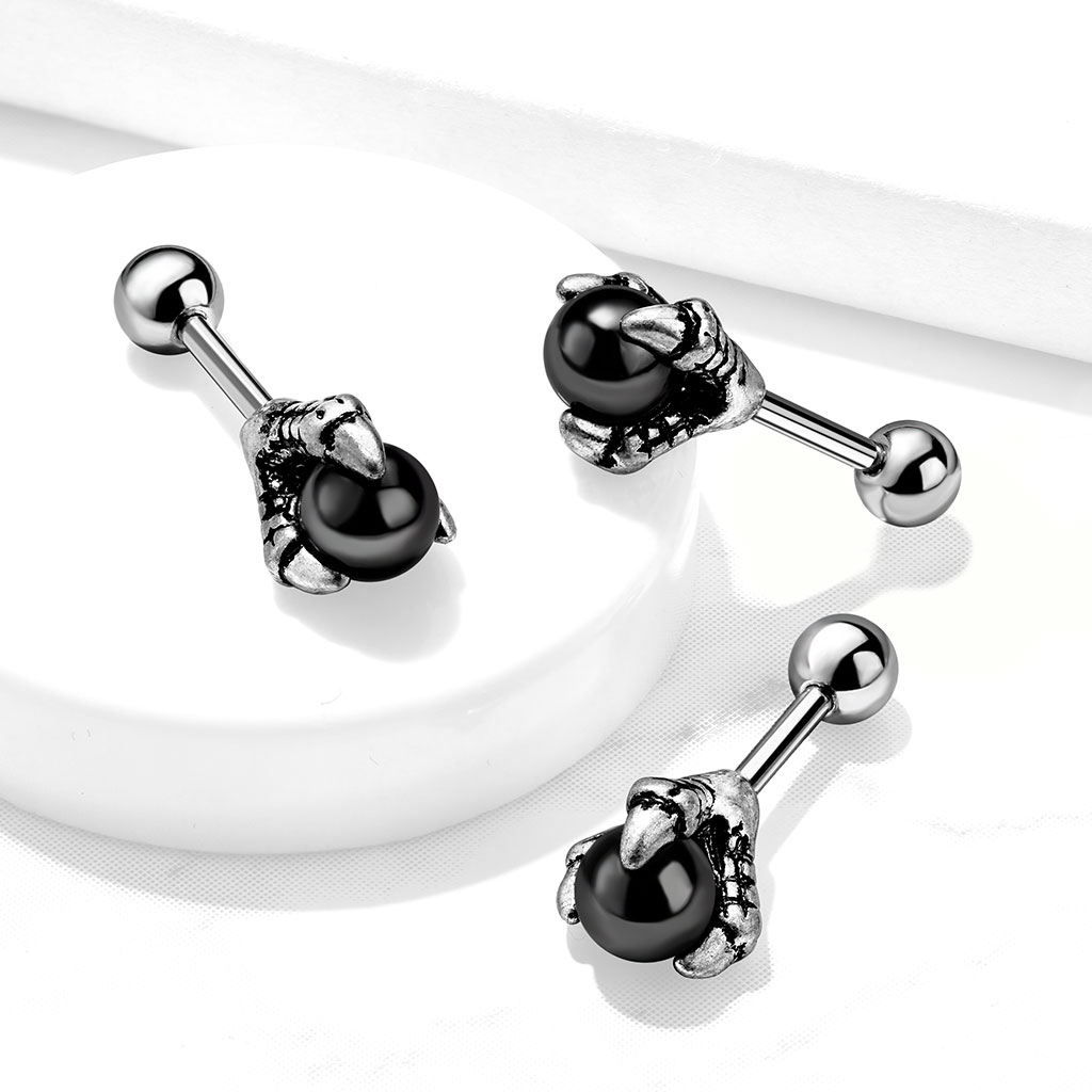 Ear piercing with black ball in dragon claw