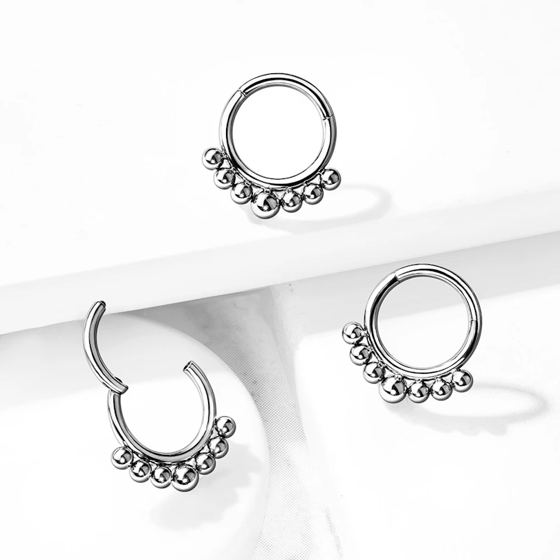 Ring made of titanium with a hinge and small beads